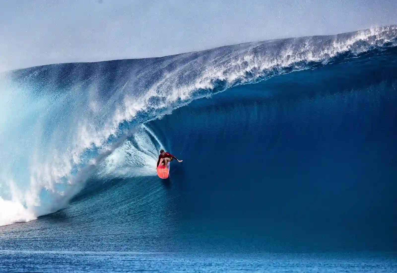 Surfer riding a challenging wave at Cloudbreak, Fiji's renowned surf spot.