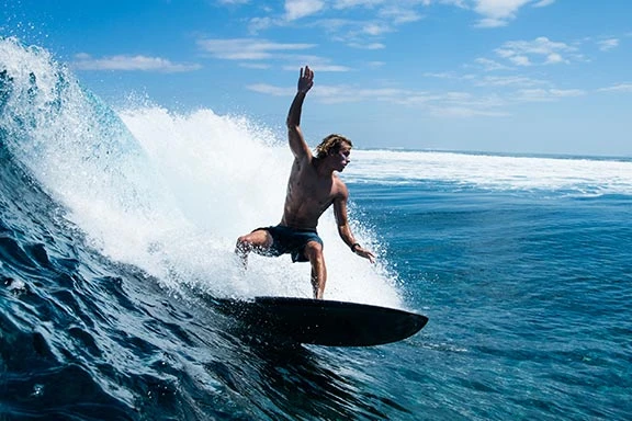 Wave rider at Swimming Pools surf spot near Namotu Island, Fiji.