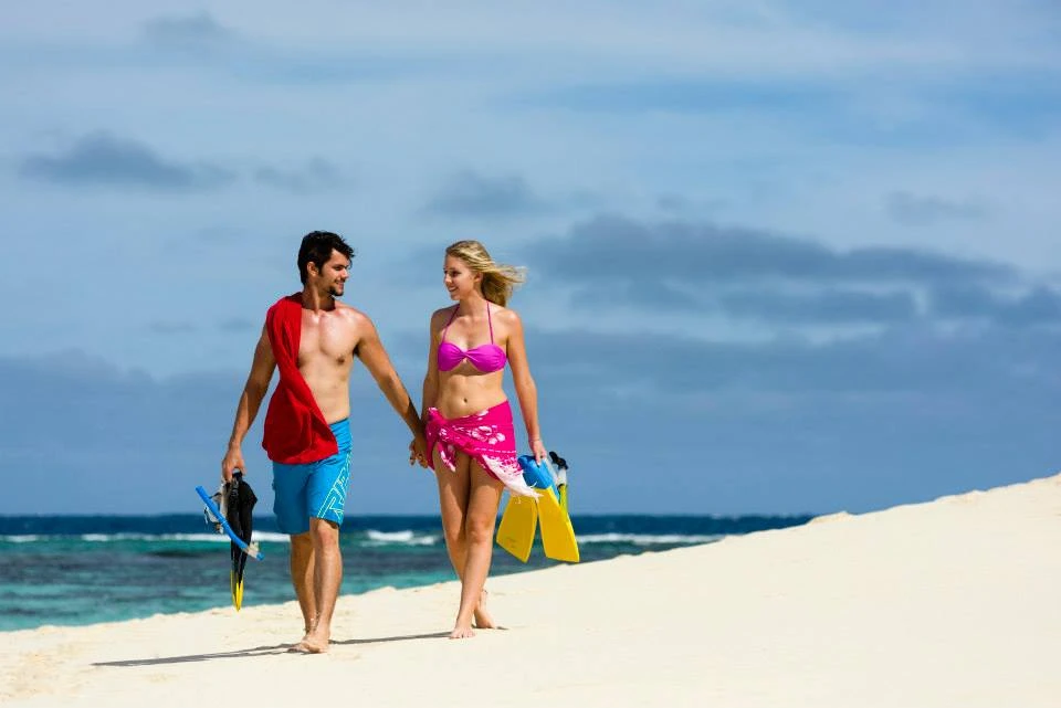 couple walking along beachat Matamanoa island resort